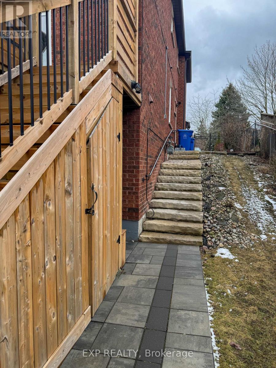 A wooden fence with a metal railing is in front of a brick building.