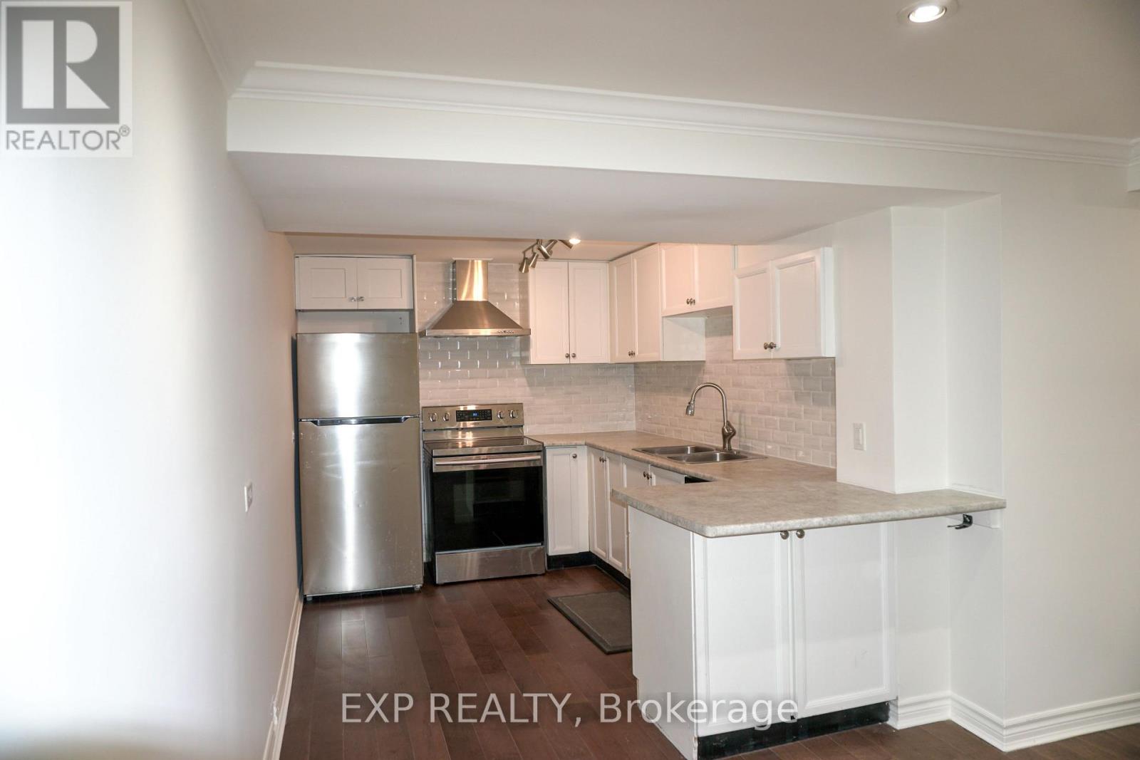 A kitchen with white cabinets and a marble countertop.