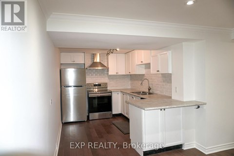 A kitchen with white cabinets and a marble countertop.