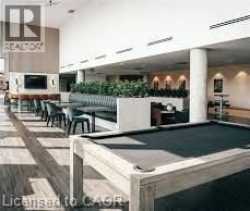 A pool table in a room with a bar and seating area.