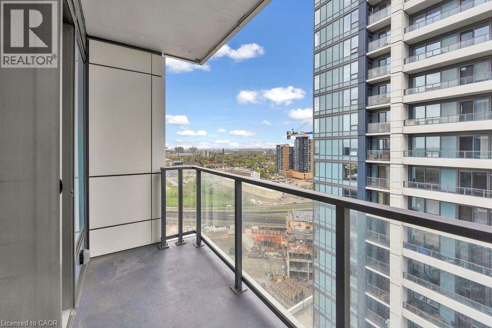 A balcony with a glass railing and a view of a construction site.