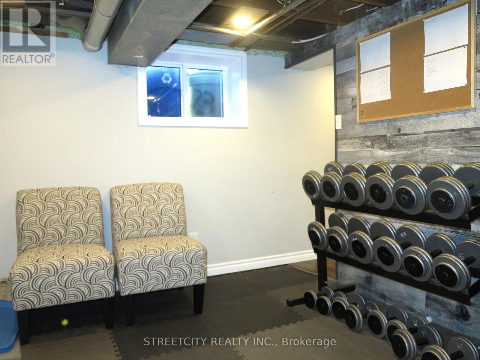A gym room with two chairs and a rack of dumbbells.