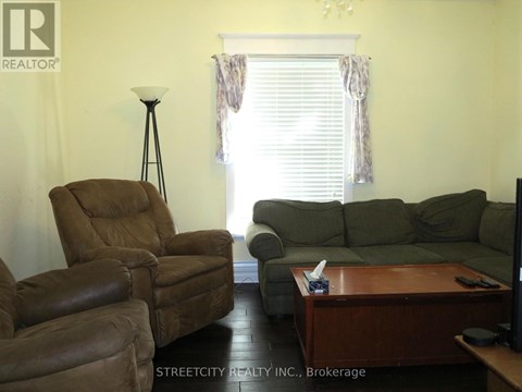 A living room with a brown leather chair and a green sofa.