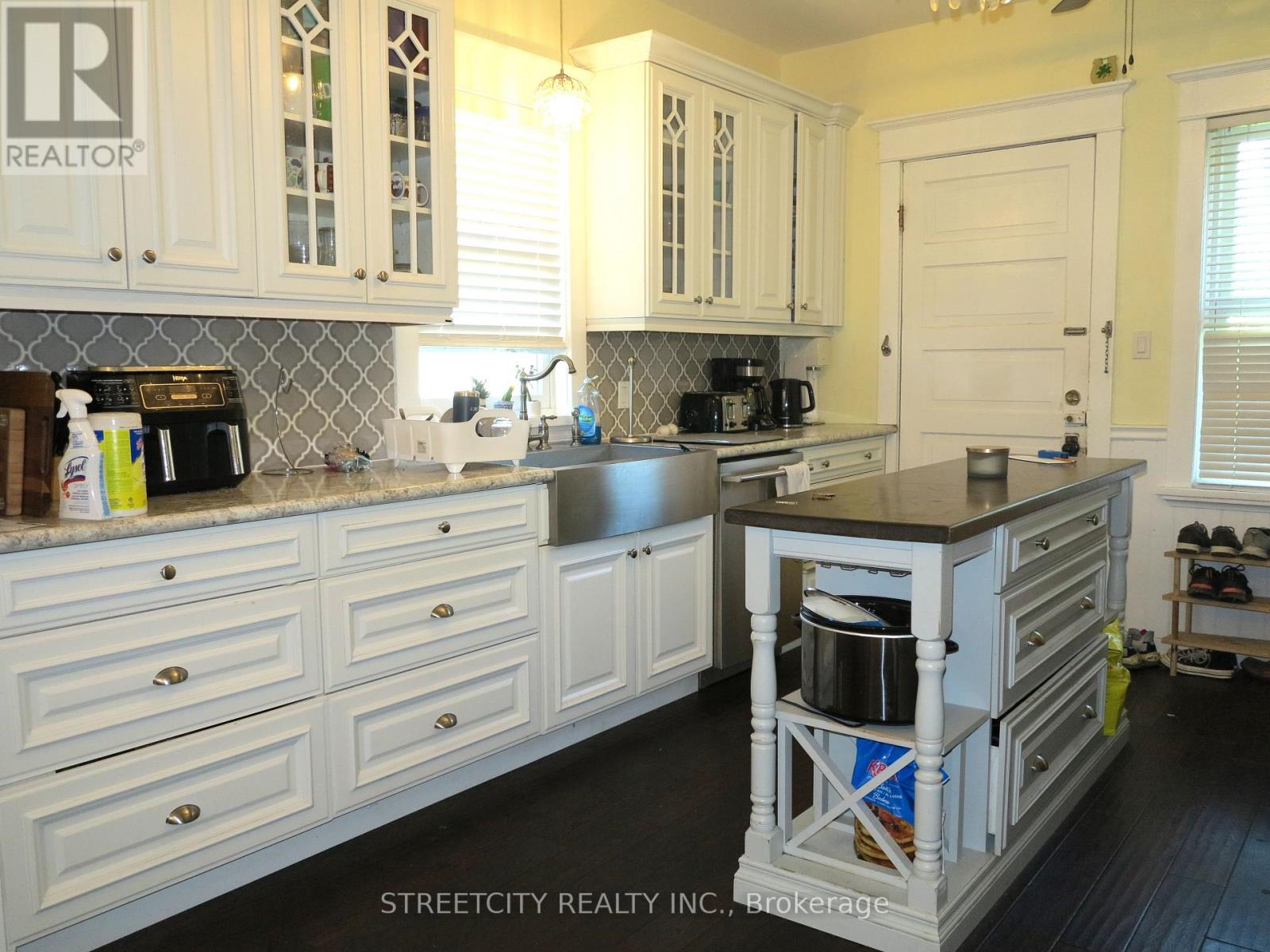 A kitchen with white cabinets and a black countertop.