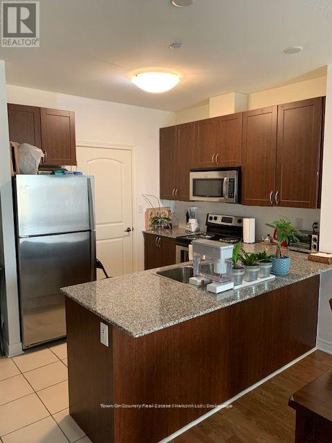 A kitchen with a granite counter top and stainless steel appliances.