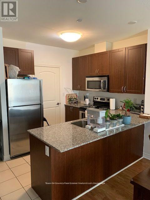 A kitchen with a granite counter top and stainless steel appliances.