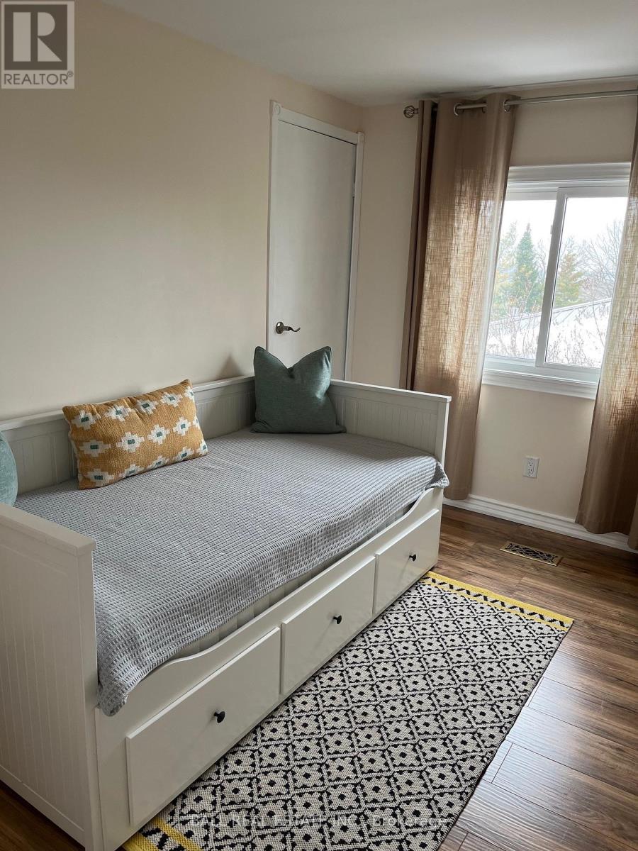 A bedroom with a bed, pillow, and curtains.