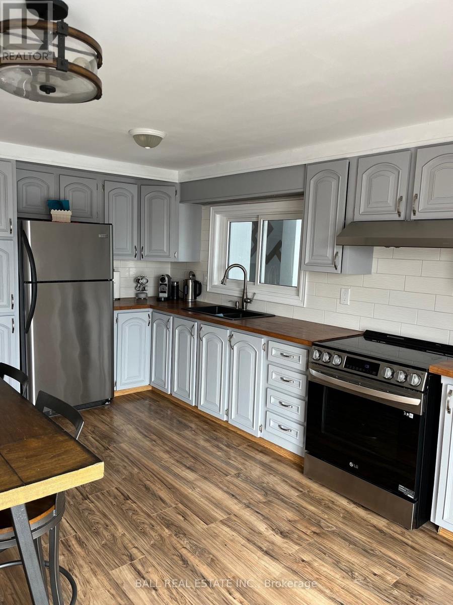 A kitchen with a refrigerator, oven, and cabinets.