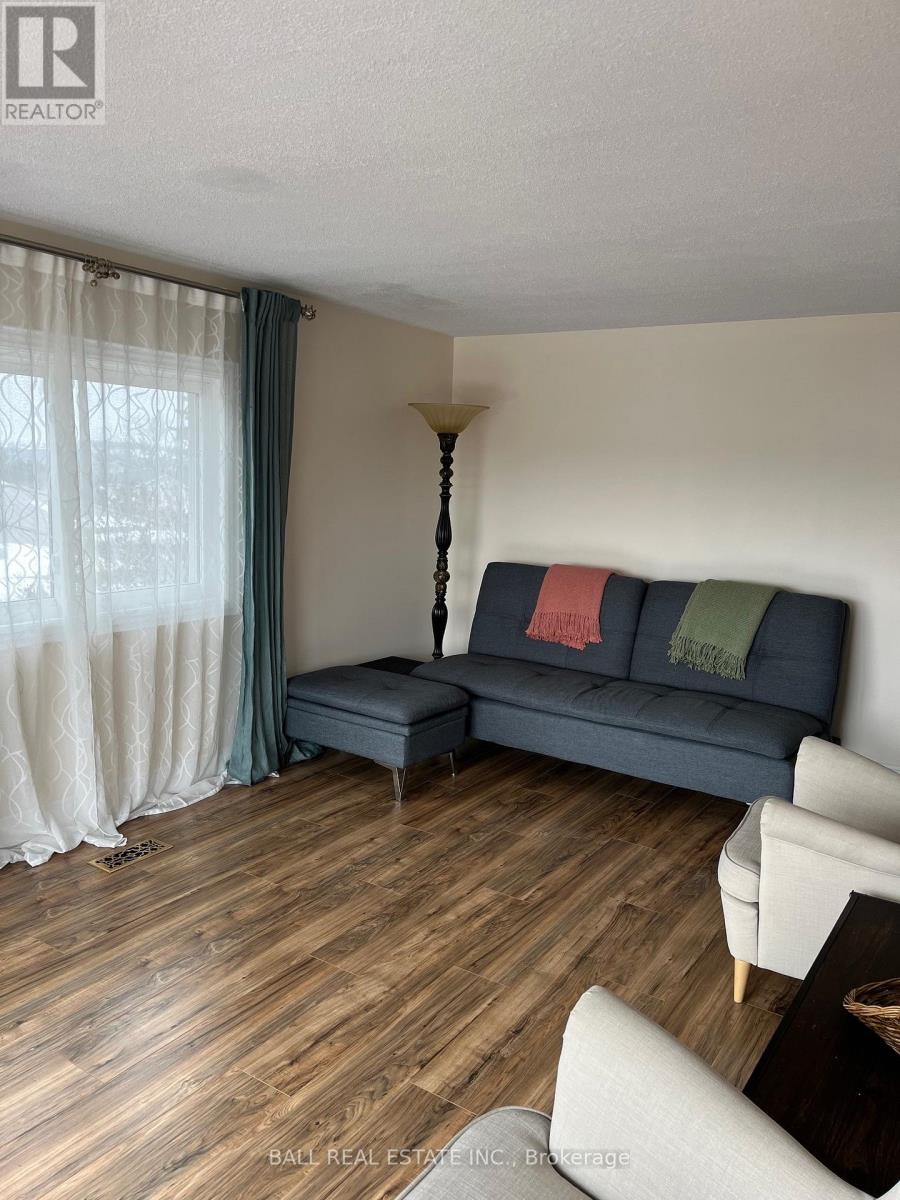 A living room with a blue couch and a wooden floor.