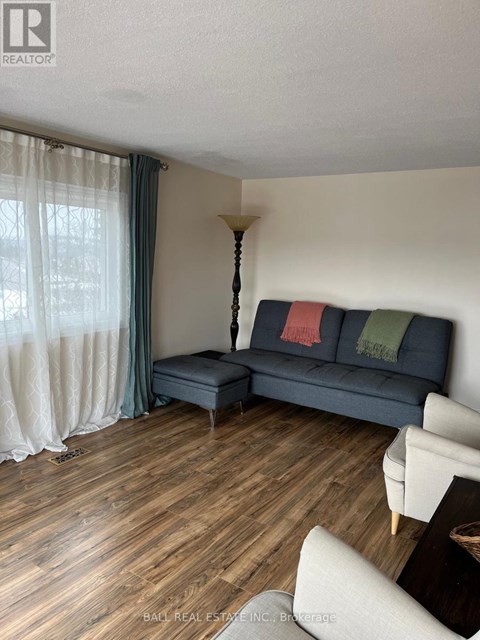 A living room with a blue couch and a wooden floor.