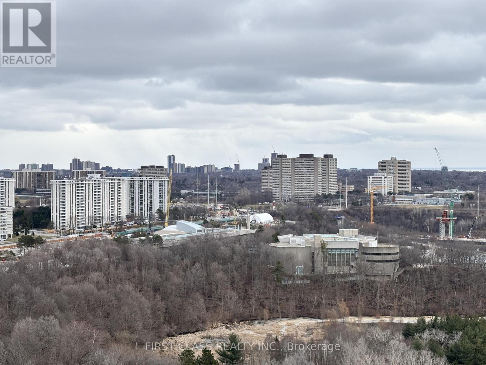 A cityscape with buildings and trees in the foreground.