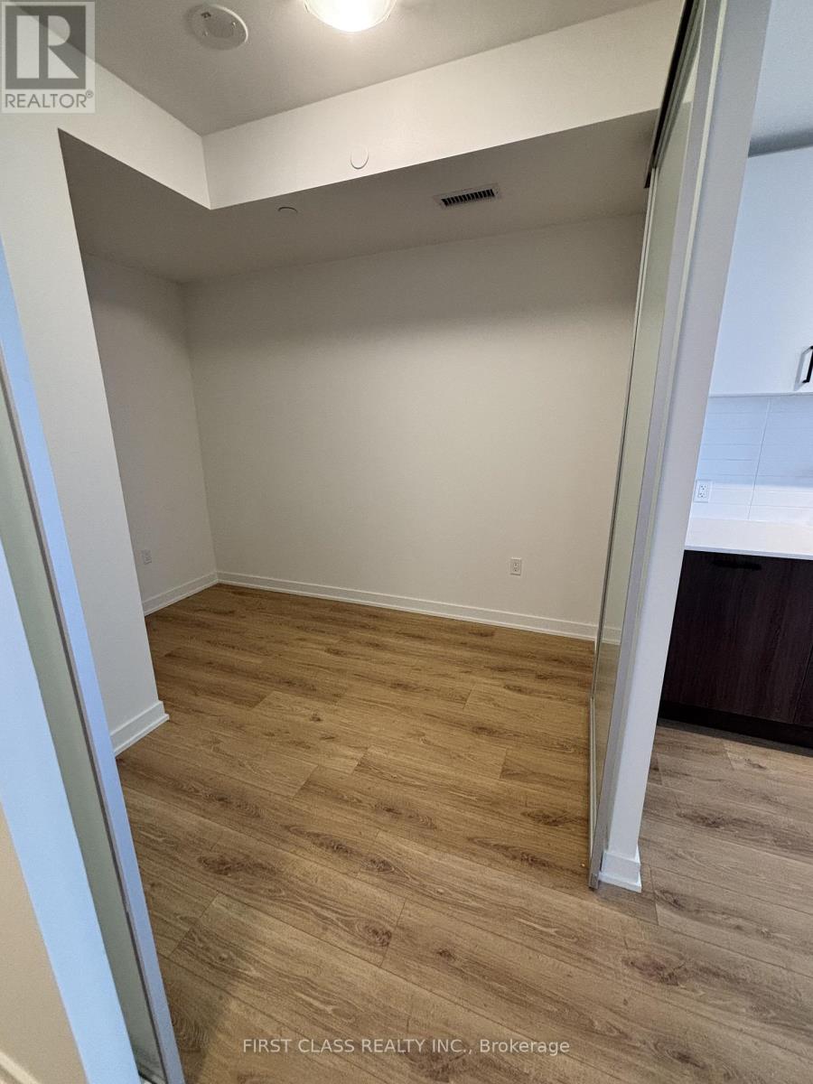 A room with wooden flooring and white walls.