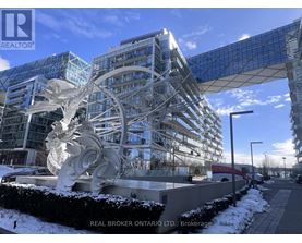 A large white sculpture in front of a glass building with the words "REAL BROKER ONTARIO LTD." on the bottom left.