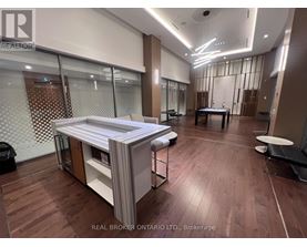 A modern office space with wood flooring and a glass wall.
