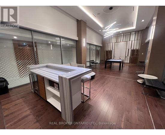 A modern office space with wood flooring and a glass wall.