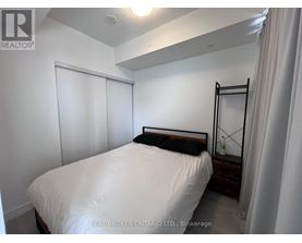 A bedroom with a white bed and a black headboard.