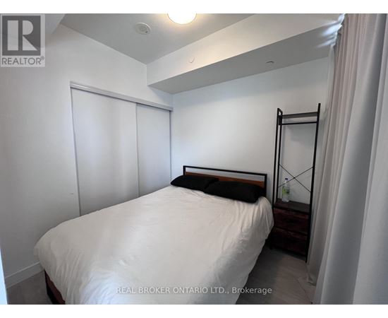 A bedroom with a white bed and a black headboard.