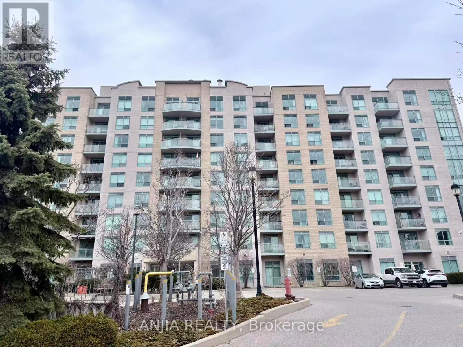 A large apartment building with a parking lot in front.