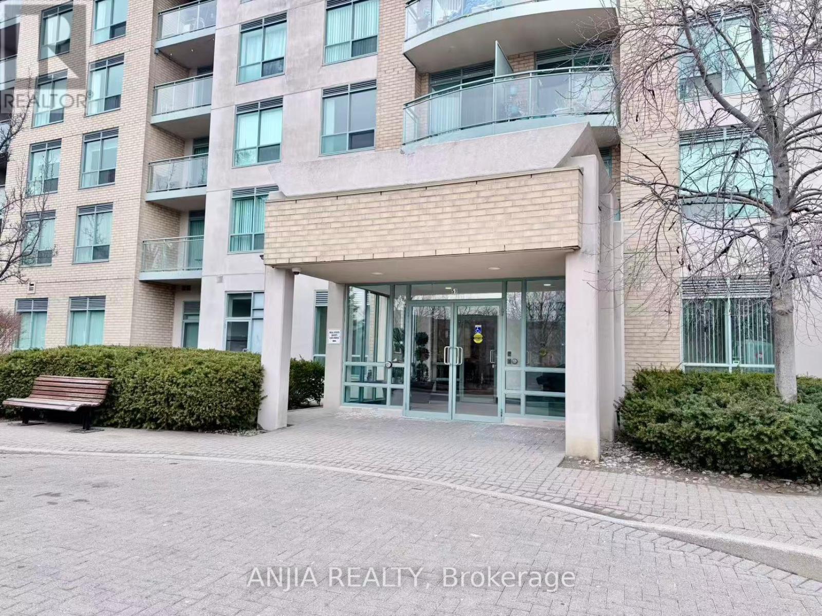 A building entrance with a bench in front of it.