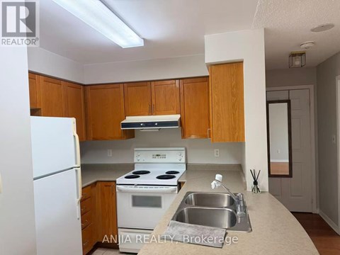 A kitchen with wooden cabinets and white appliances.