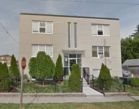 A two-story building with a stop sign in front.