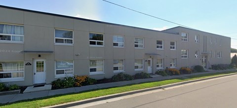 Apartment building with a green lawn in front.
