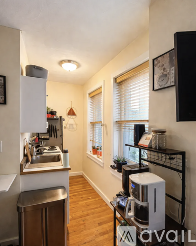 A kitchen with a white refrigerator and a stainless steel trash can.