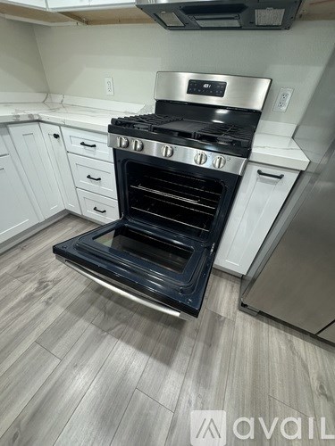 A modern kitchen with a stainless steel oven and white cabinets.