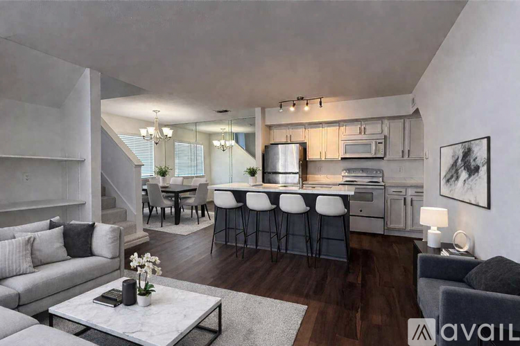 A modern kitchen with a breakfast bar and a dining table with chairs.