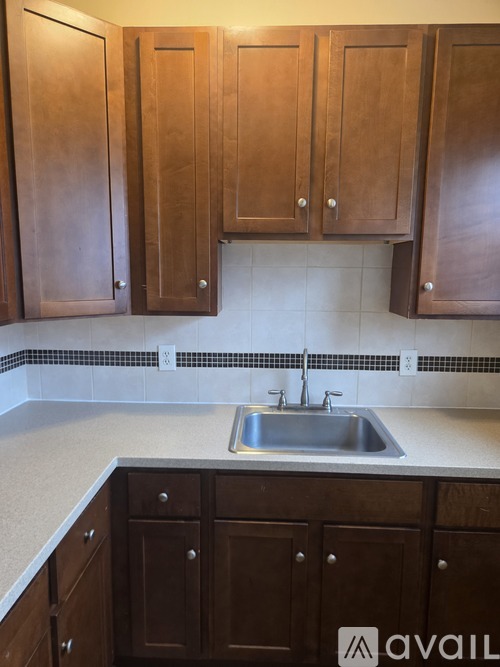A kitchen with brown cabinets and a sink.