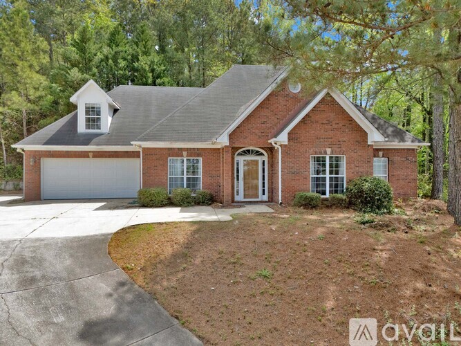 A brick house with a white garage door and a driveway.