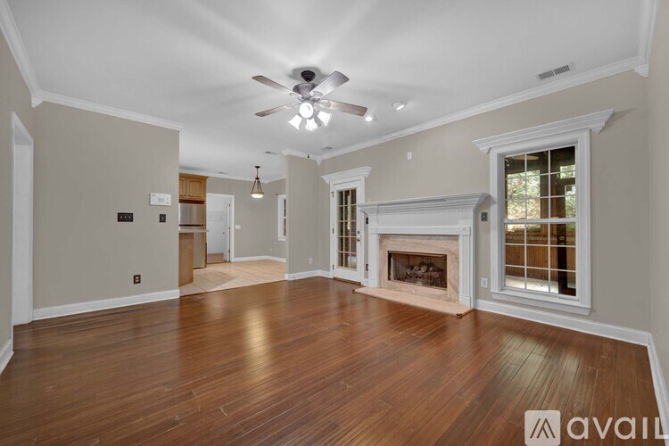 A spacious living room with hardwood floors and a fireplace.