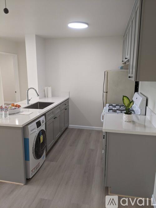 A modern kitchen with a washing machine and a refrigerator.