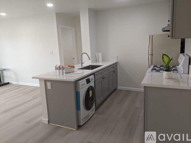 A modern kitchen with a washing machine built into the cabinetry.