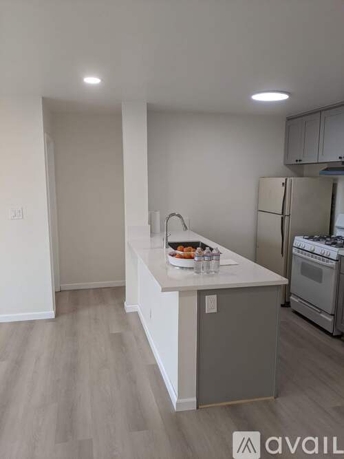 A kitchen with a white countertop and a refrigerator.