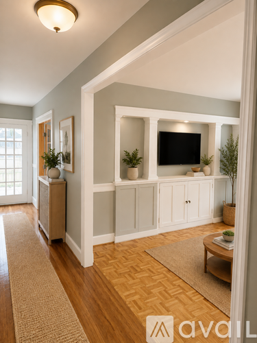 A living room with a television and a rug on the floor.