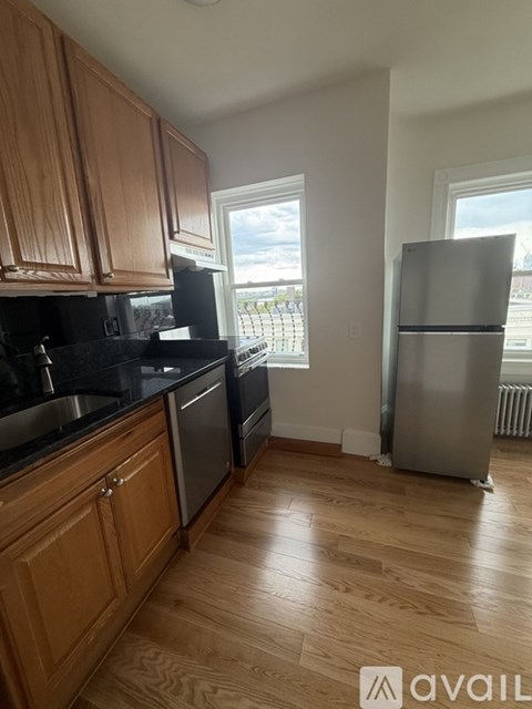 A kitchen with wooden cabinets and a black countertop.