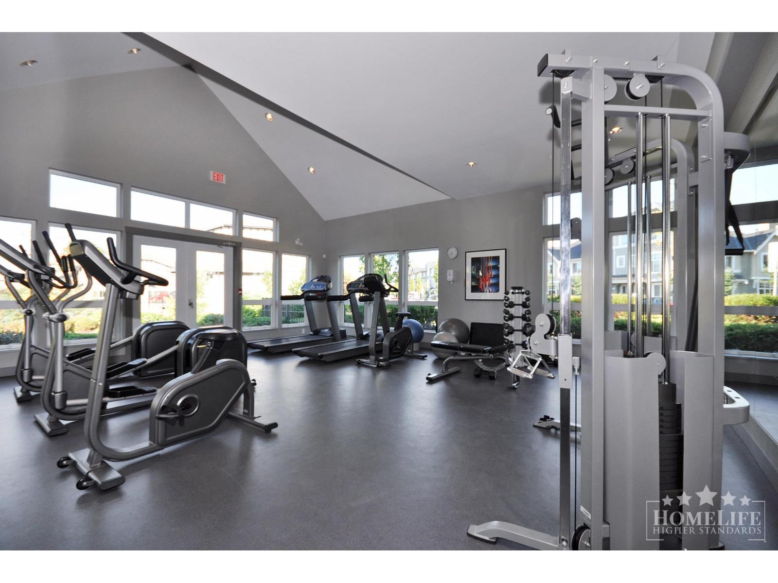 A gym with a variety of equipment including treadmills, weights, and exercise machines.
