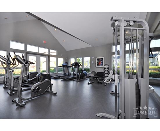 A gym with a variety of equipment including treadmills, weights, and exercise machines.