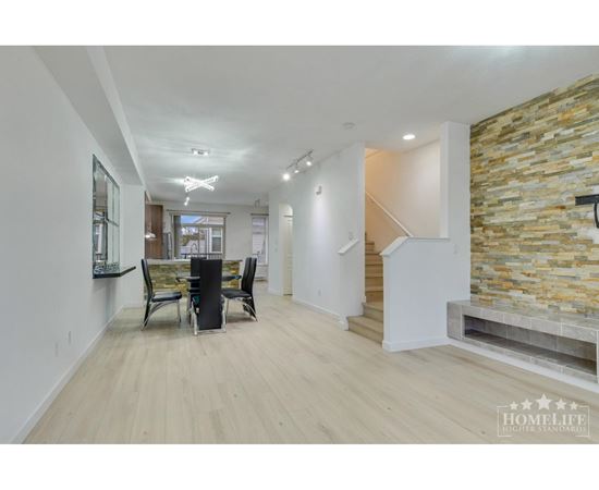 A spacious living room with a stone wall and a staircase.