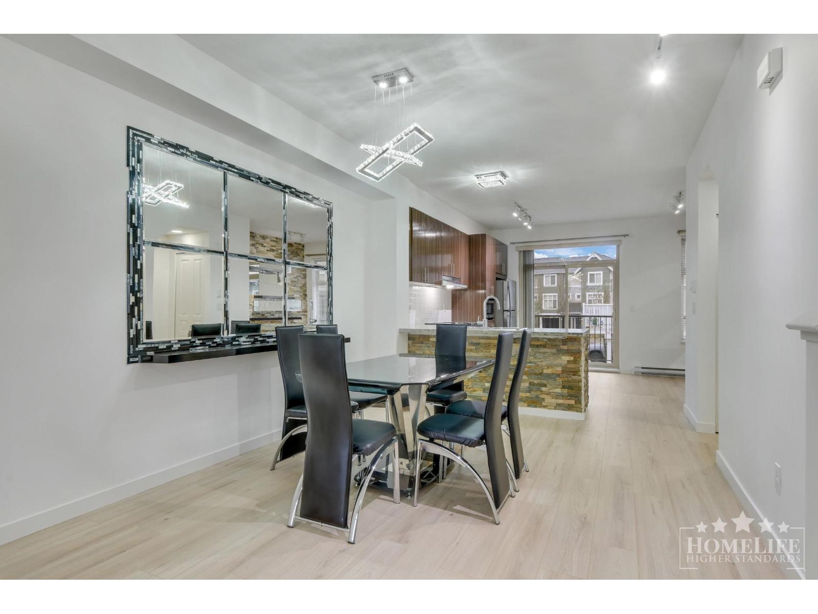 A dining room with a large mirror and a wooden floor.