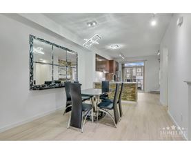 A dining room with a large mirror and a wooden floor.