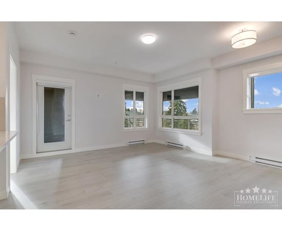 A spacious room with a large window and a door leading to another room.