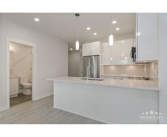 A modern kitchen with white cabinets and a large island.