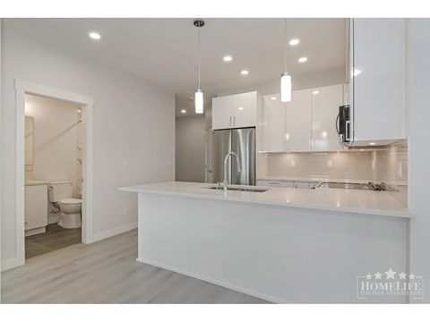 A modern kitchen with white cabinets and a large island.