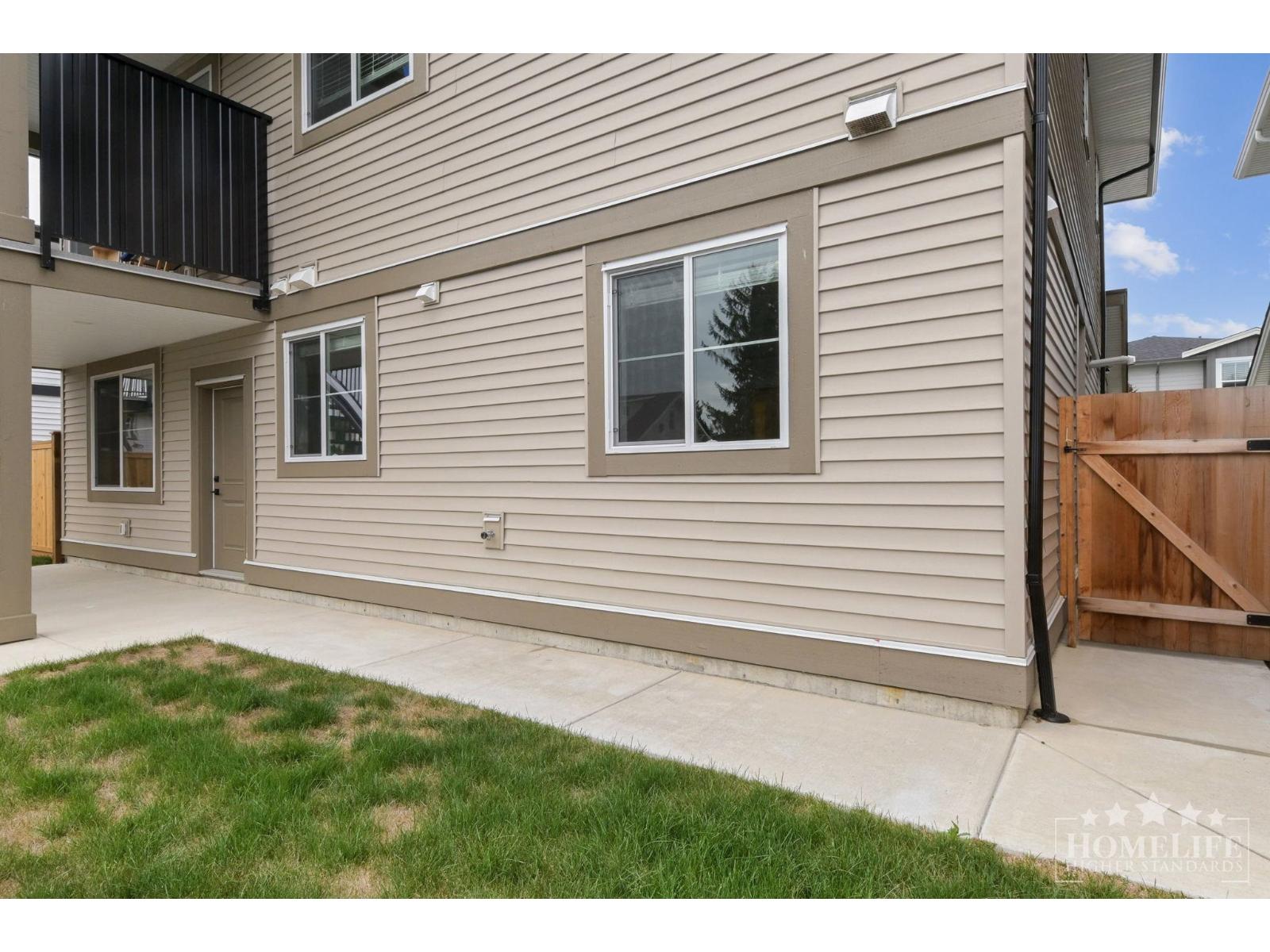A building with a grey siding and a brown fence.