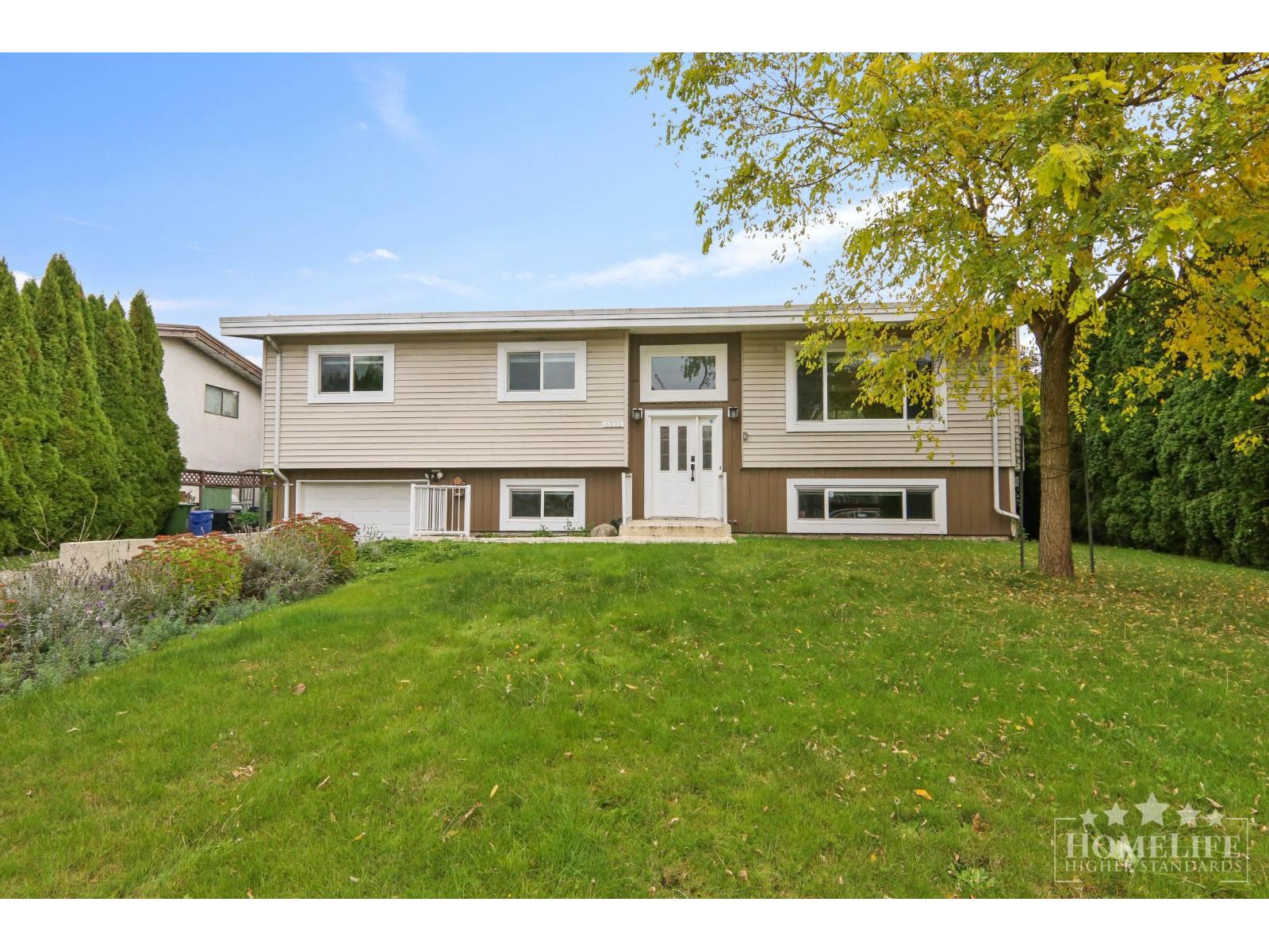 A two-story house with a large front yard.