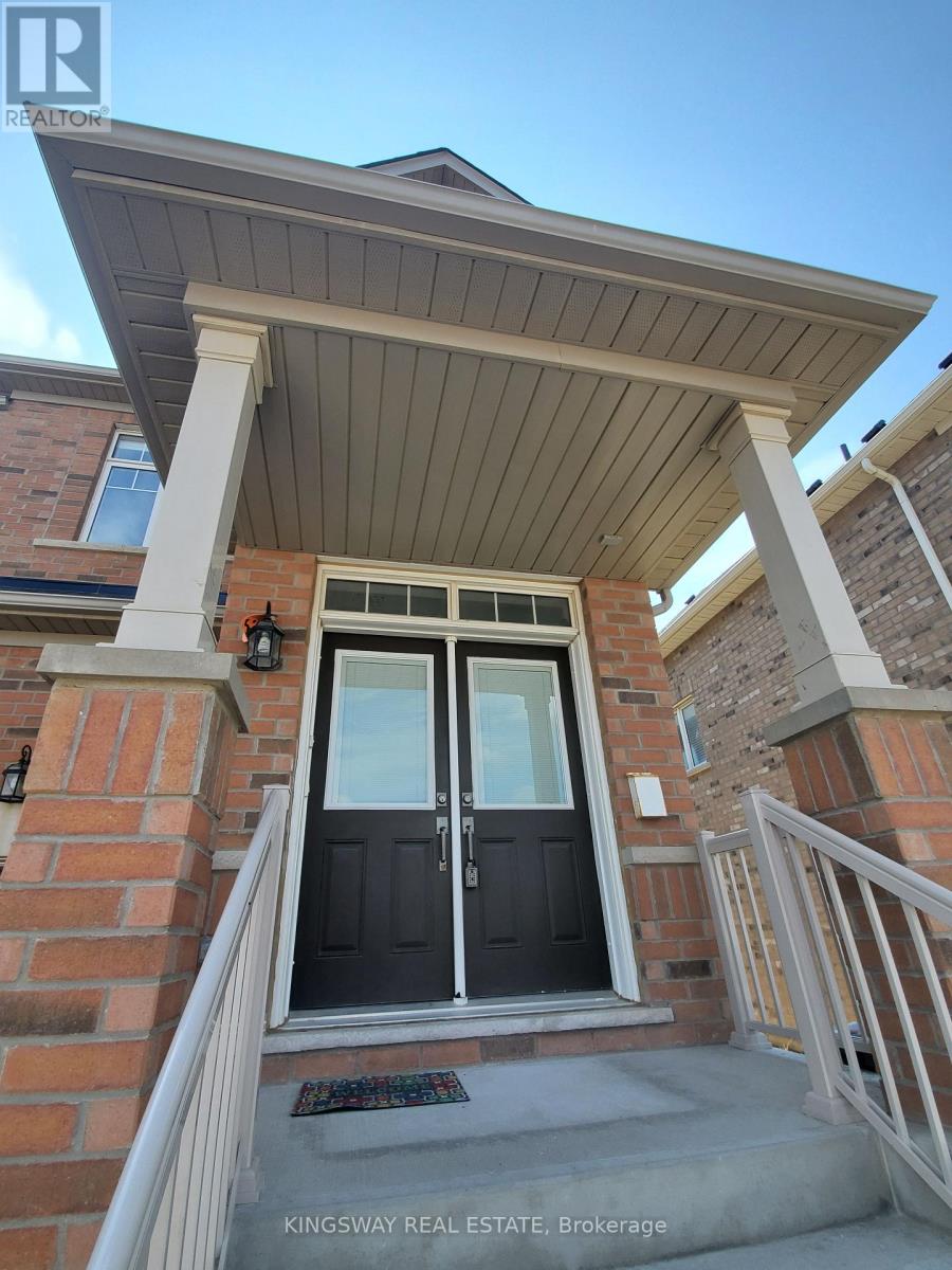 A house entrance with a black door and a brick wall.