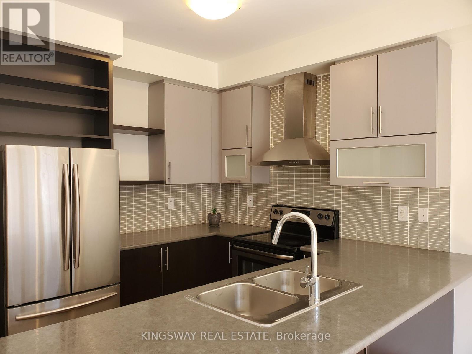 A kitchen with a stainless steel refrigerator and a sink.