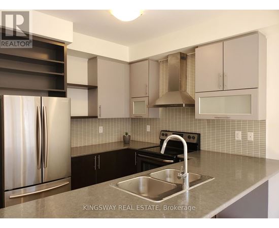 A kitchen with a stainless steel refrigerator and a sink.
